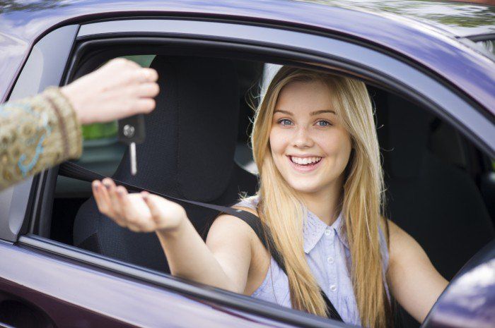 Girl borrowing the car keys of a friend or family member to drive. 